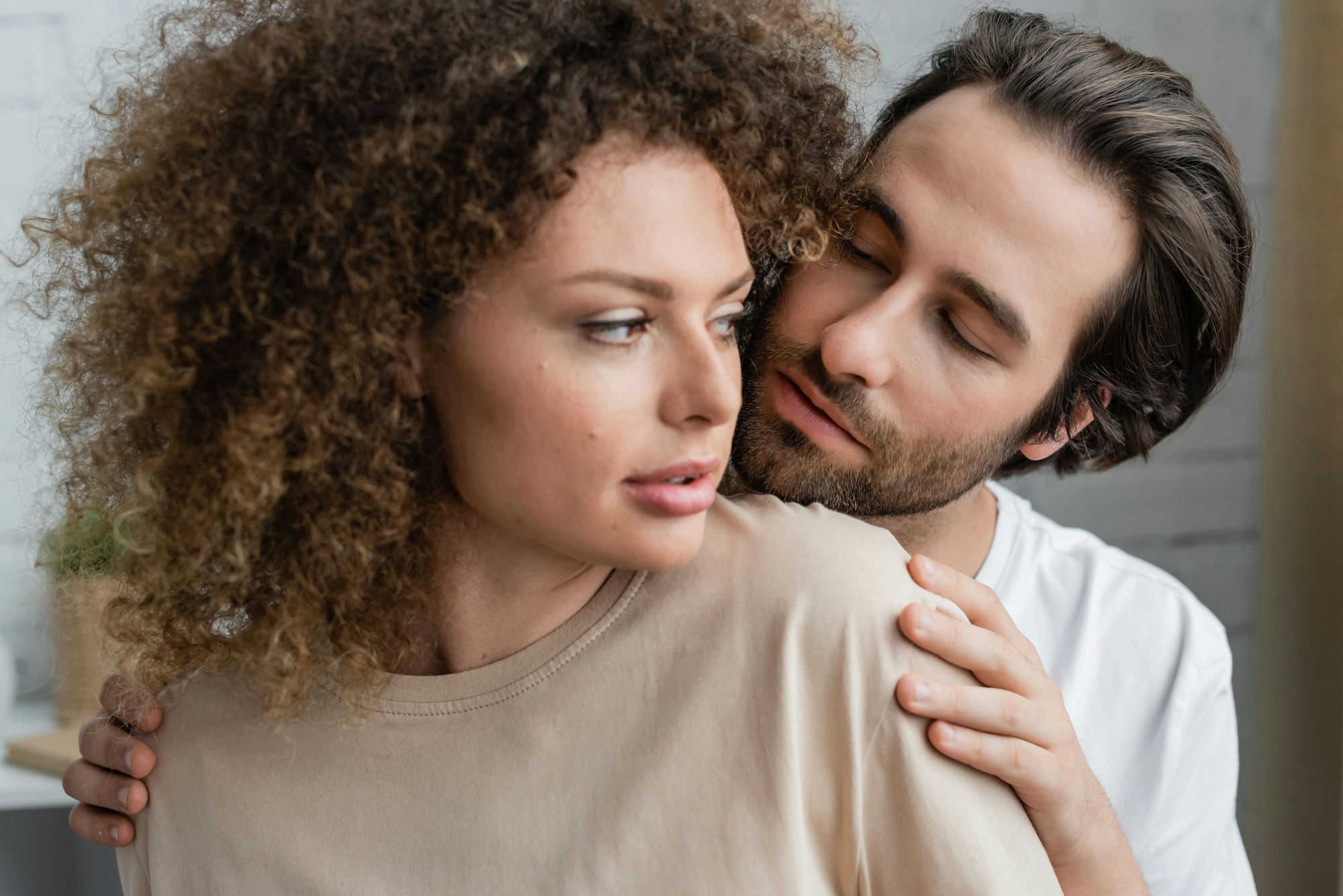 bearded man looking at seductive woman in beige t-shirt