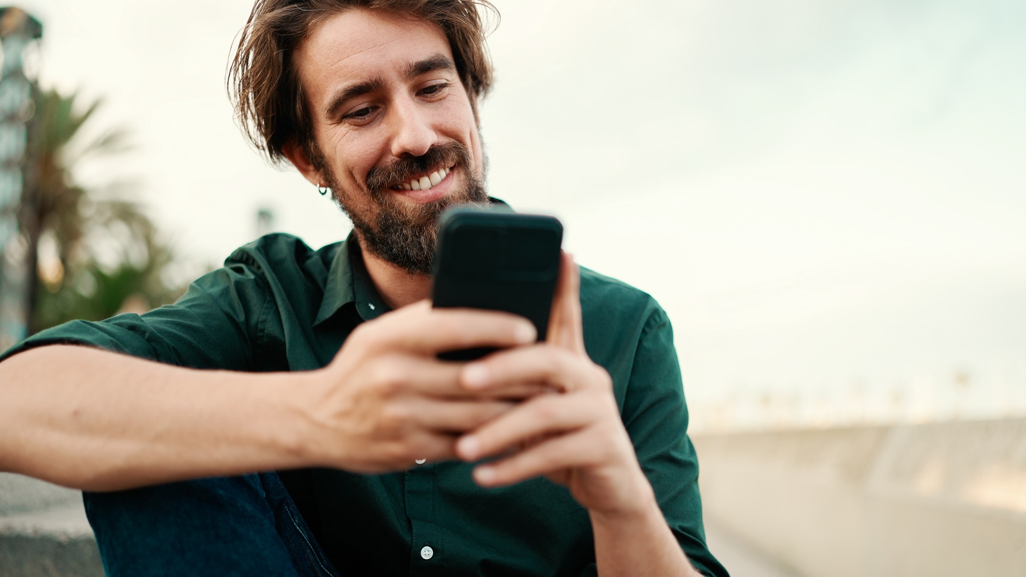 Closeup of a young hipster man using a mobile phone