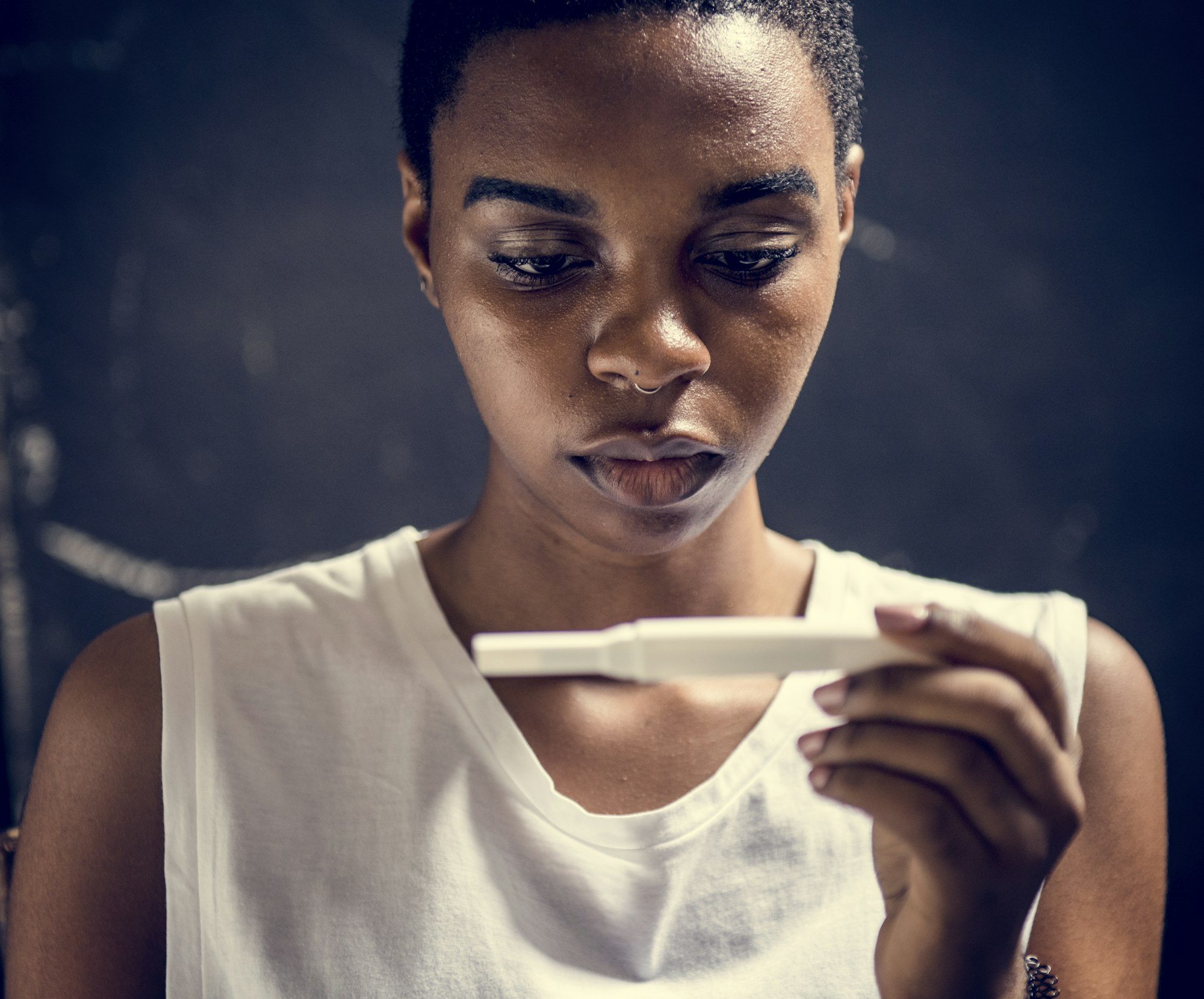 Closeup of black woman with pregnancy test in a hand