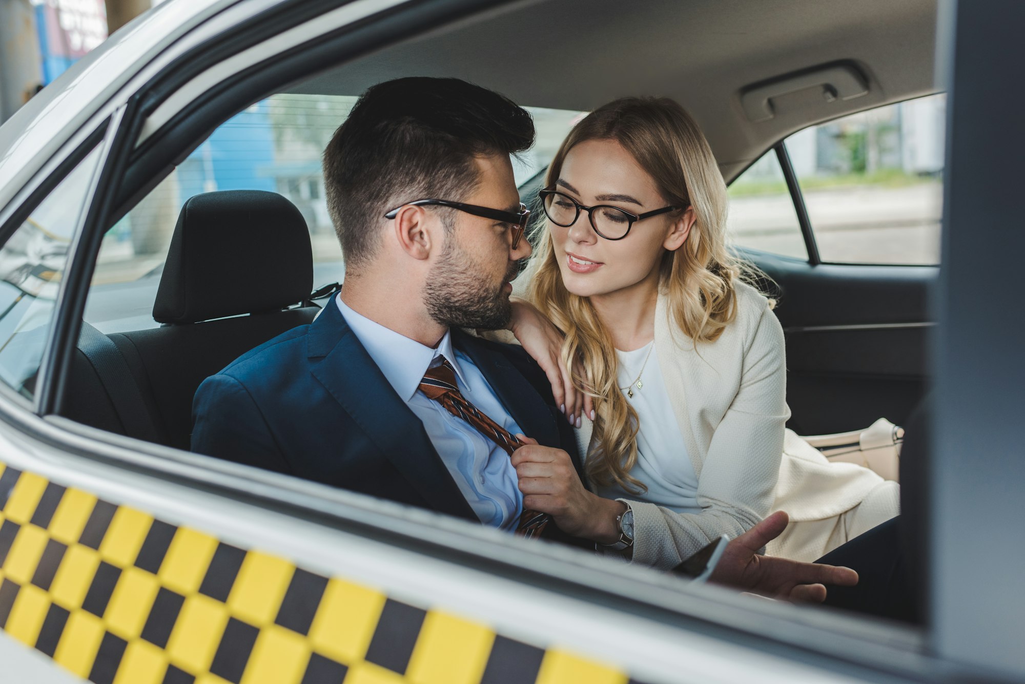 seductive young couple flirting while sitting in taxi cab