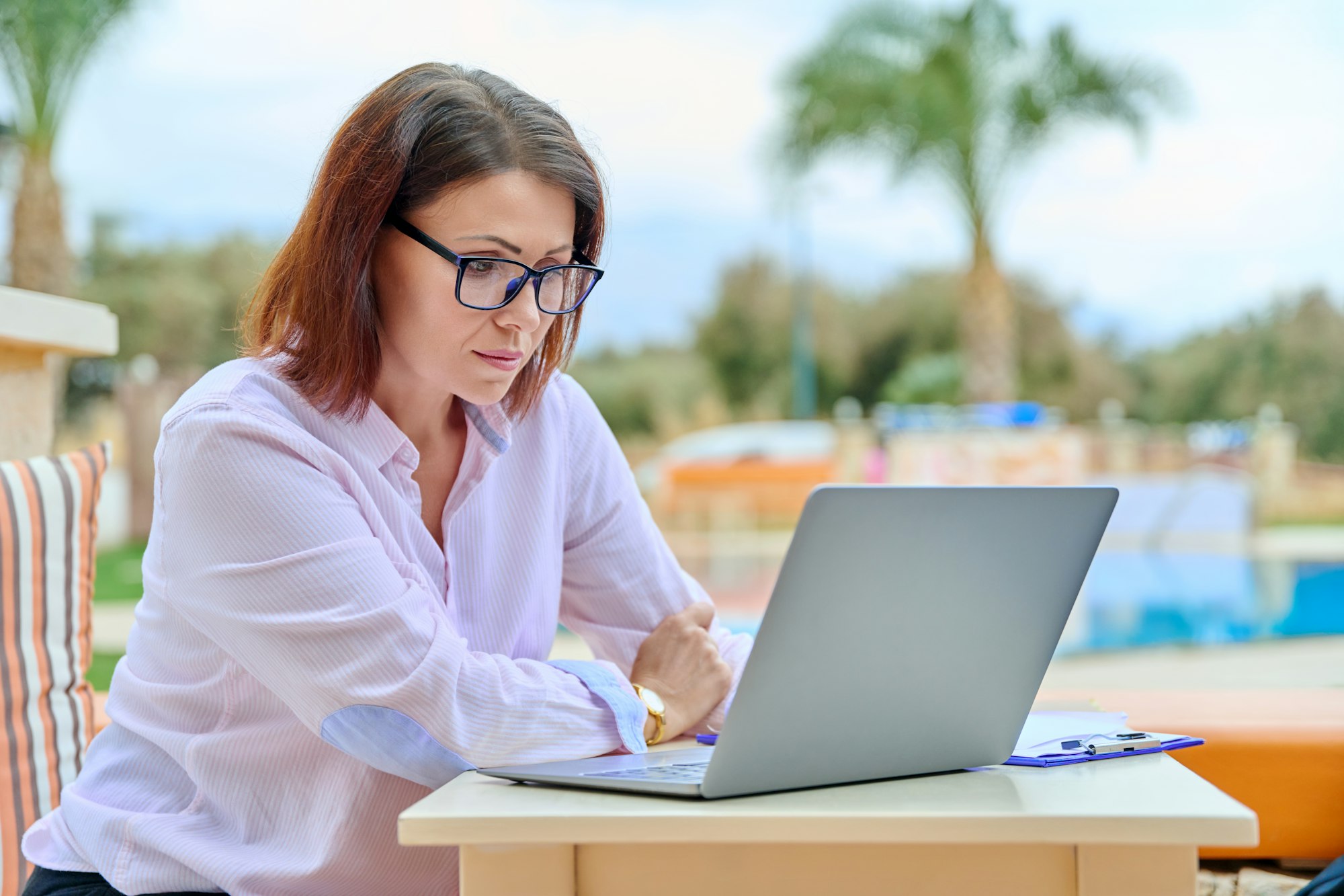 Beautiful business woman in her 40s working on a laptop remotely