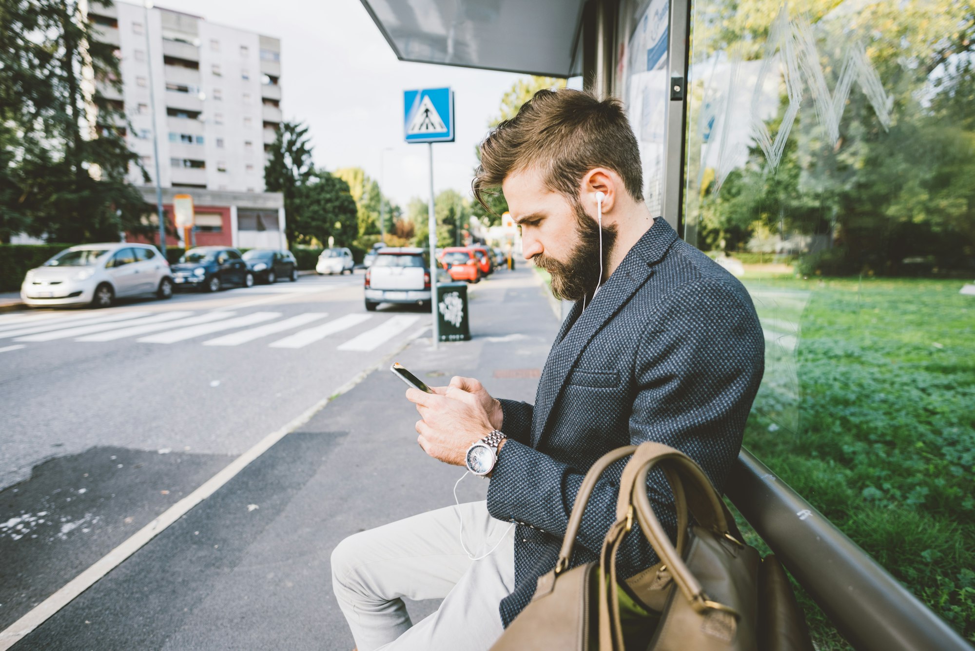 Young bearded man using smartphone listening music