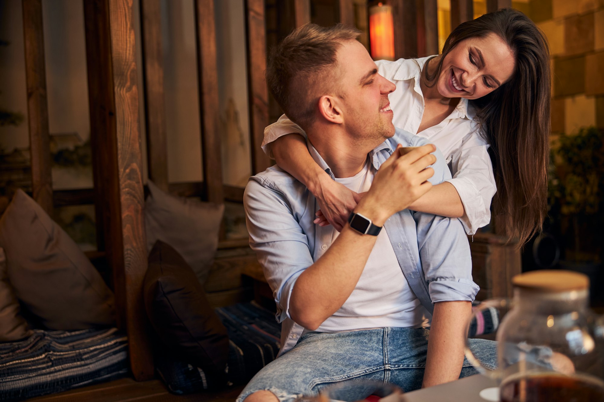 Beautiful young couple hugging in cozy cafe