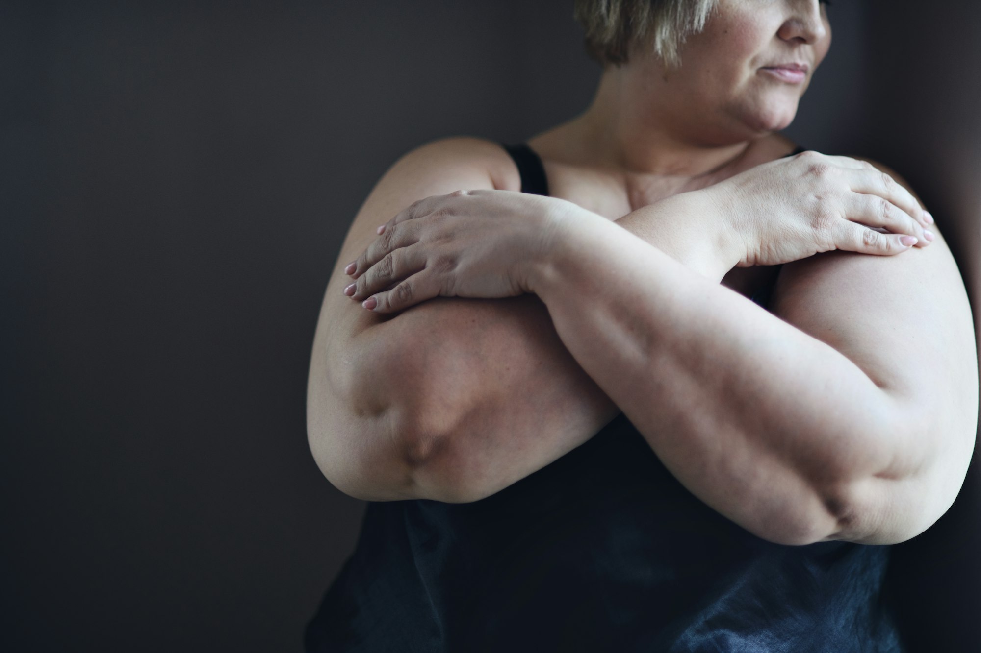 Depressed fat woman standing with arms crossed and looking through the window at home, cut out